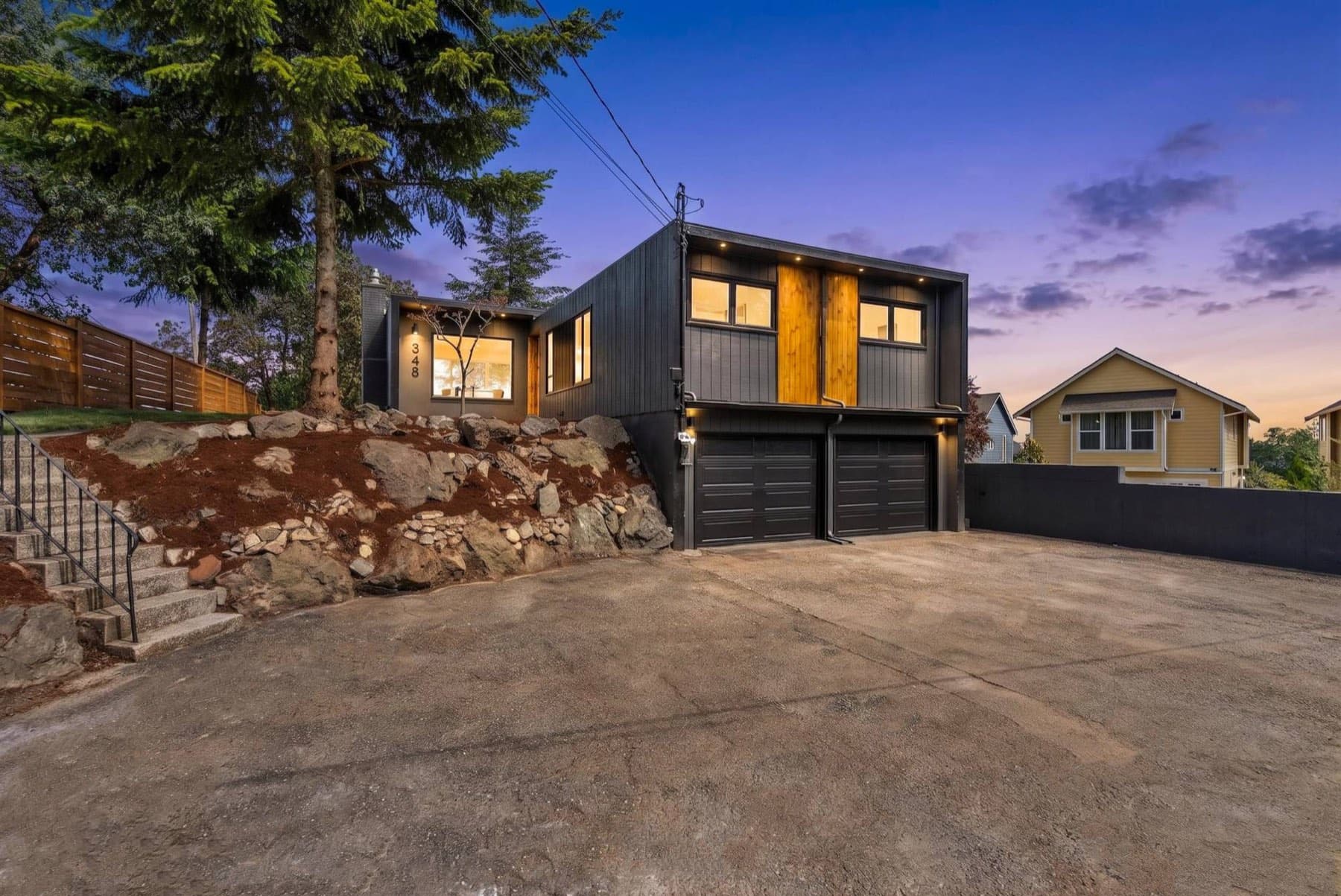 Hillside home exterior with cedar accent panels at dusk