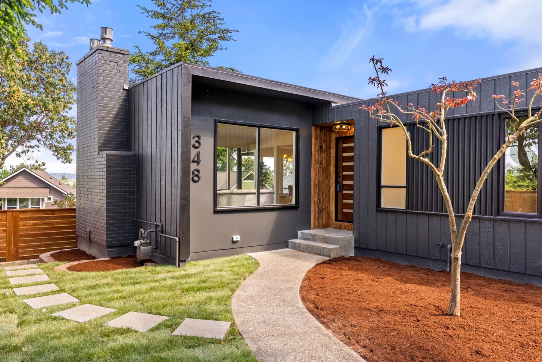 Modern entry with cedar door and dark board-and-batten siding